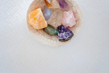 Healing crystals on a white table including: Amethyst Point and Cluster, Clear Quartz, Citrine, Calcite and Rose quartz. Gemstones are full of healing energy and good vibes.
