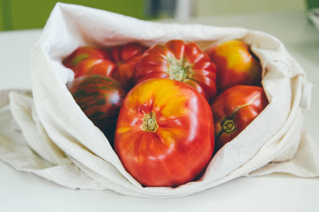Canvas eco tote with red tomatoes. Local market vegetables. Eco friendly grocery bag