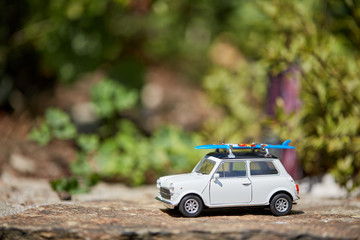 Obraz na płótnie Canvas Mini toy car with sufboard on roof figurine for summer holiday