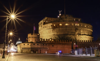Fototapeta na wymiar Rome at night. In foreground is Saint Angel Castle, in background Vatican and Dome of St. Peter's Basilica