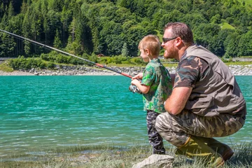 Fotobehang father and son fishing together on a mountain lake © Lsantilli