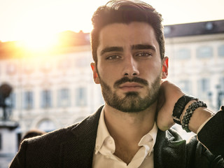 Handsome serious businessman standing outside in elegant European city center, Turin in Italy