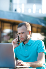 Young business man with glasses uses phone