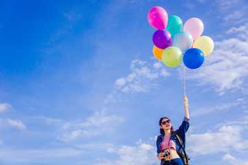 girl's travel and holds a ball of light color on a bright day sky background