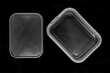 Transparent plastic box bottom separated from lid and isolated on black background surface