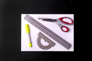 Concept Back To School white sheet with tools on a black chalkboard