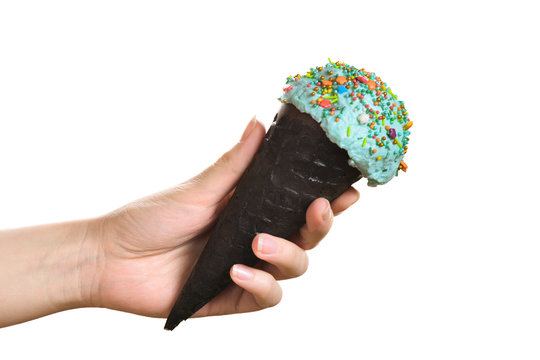 Woman's Hand Holding Black Wafer Cone With Blue Ice Cream. Isolated On White.