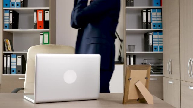 Tired businessman enters the office then turns on the air conditioning system with a remote. Hot and exhausted man in forman wear
