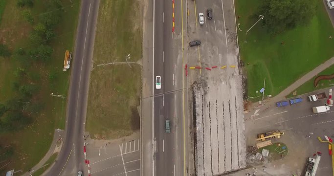 Aerial drone footage with road bridge construction in Minsk, Belarus. View from above over highway repair. Building a new bridge on suburban road. Truck crane and other specializes equipment and car's
