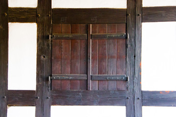 A closed window with wooden shutters of a Timbered house in the palatine region in the state Rhineland-Palatinate, Germany. Concept of closed, shuttered, not welcomed or also evening and not disturb