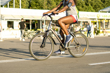 unrecognizable afro american woman riding a bicycle in the summer park