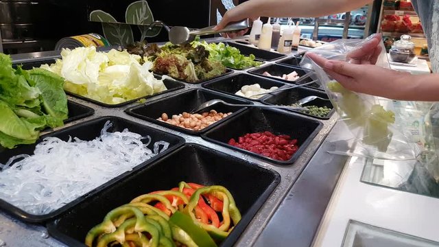 footage of woman select different vegetable on catering buffet food in hotel restaurant with colorful fruits and vegetables for salad food ,vegetarian. footage video for healthy people 
