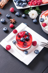 Proper nutrition, jelly cake, cottage cheese with fruit on a black wooden background