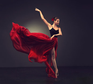 Ballerina. Young Graceful Woman Ballet Dancer, Dressed In Professional Outfit, Shoes And Red Weightless Skirt Is Demonstrating Dancing Skill. 
Beauty Of Classic Ballet Dance. 
