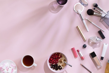 Top view of elegant woman make up table with pink and white accents and shadows on background, female morning with healthy breakfast oat flakes with berries, flat lay and copy space