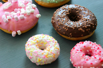 Photos of different donuts. Assorted colorful donuts in glaze close-up.