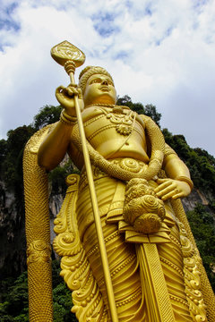 View of the Batu Caves with a golden and giant statue of Lord Murugan. The limestone cave with its steps is one of the most popular Hindu shrines outside India, and is dedicated to Lord Murugan