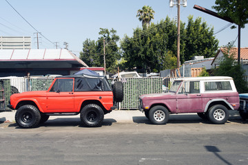 A view of two vintage suv truck cars in the street in Venice, California