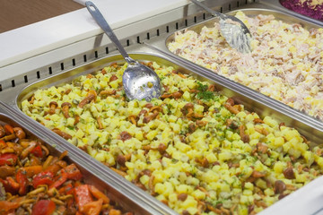 View of a different prepared salads on the counter in the store