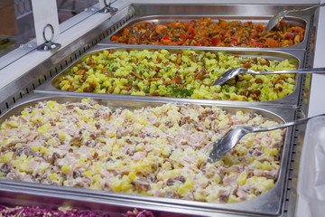 A different multicolored prepared salads on the counter in the store
