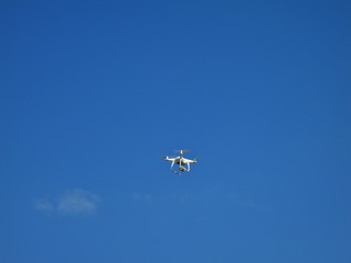 Flying drone against the blue sky
