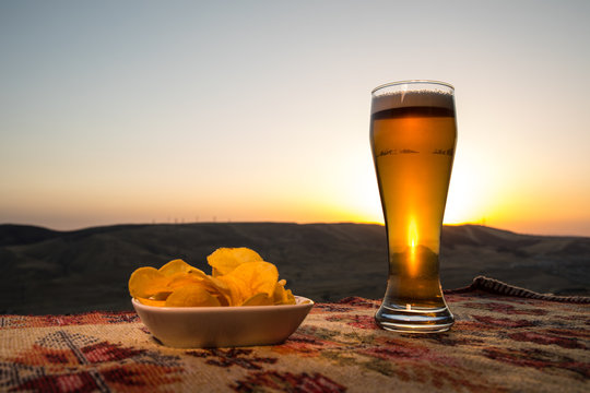 Close Up of A Glass of Beer with the snacks on Sunlight Background, beer on grass
