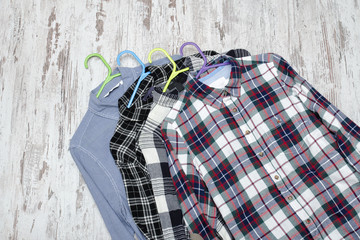 Three checkered shirts on wooden background. Fashionable concept