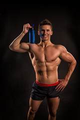 Fototapeta na wymiar Do not forget to drink water. Man bodybuilder posing with tense muscles on black background. Bodybuilder achieved best shape for muscles. Care about water balance. Bodybuilder perfect muscular body