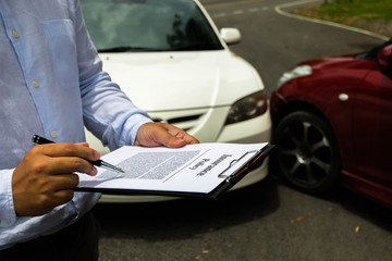 The insurance agent examining car after accident on the road. Insurance claim concept .