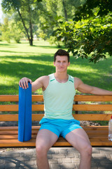 Relax concept. Athlete relax on bench in park. Sportsman relax after yoga training. Relax and enjoy life