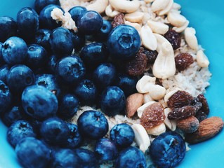 Healthy breakfast in a blue bowl. Oatmeal with blueberries and nut mix. Healthy food concept. Top view, side view. Space for text.