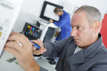 middle age man fixing a printer