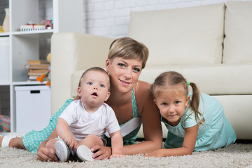 mom with two children playing at home in the room, children one year and four years of age