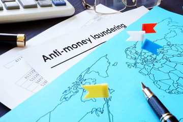 Anti-Money Laundering (AML) documents and world map.