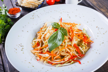 Fresh salad with apple, carrot, cabbage, celery and lemon on wooden background close up. Healthy food. Top view