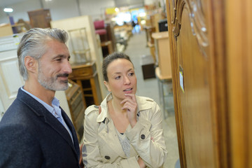 pretty woman with salesman in furniture store