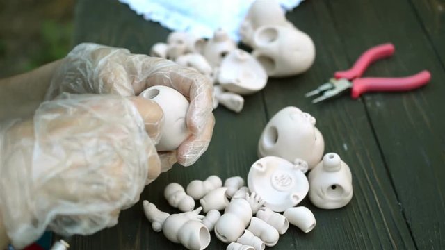 Human hands make dolls of BJD or reborn in the workplace. Processing the workpiece. The concept of the craft of the master manufacturer of dolls. Selective focus. Close-up.