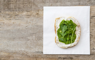 Top view of open sandwich with cream cheese, pesto and rucola