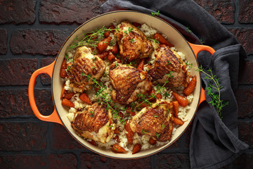 Free range chicken thighs with rice and honey glazed chantenay carrots in pan