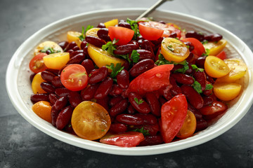 Healthy Red beans and mix of organic red and yellow cherry tomatoes salad topped with parsley.