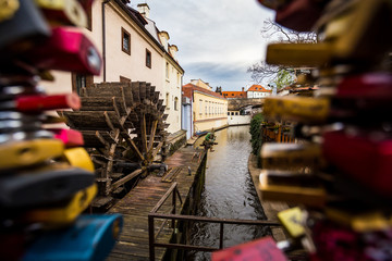 Love locks on a fence by old water mill on Kampa Island in Prague, Czech Republic.