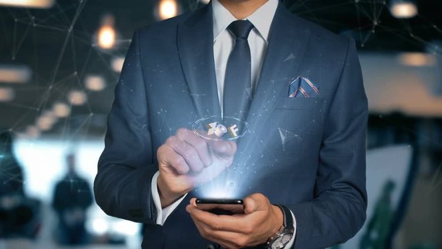 Businessman With Mobile Phone Opens Hologram HUD Interface and Touches Iso Curreny Code of West Arican Franc - XOF