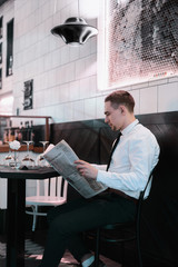 Businessman seating at restourante reading a newspaper