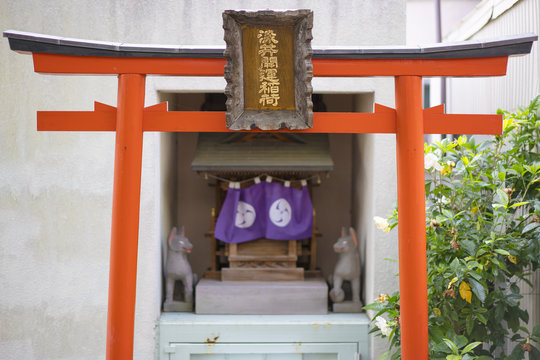 Shinto neighborhood sanctuary with torii portal dedicated to Inari fox deity in Komagome's Somei Ginza shopping street.