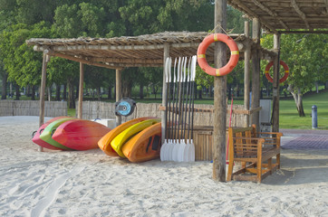 Plastic mass products kayaks of various colors are rented out on the sea sandy beach.