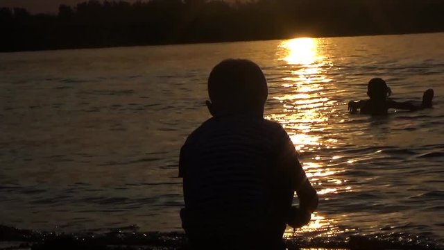 Children on the shore and in the river