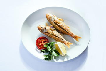 Red mullet fish aka tekir fish in plate with vegetables