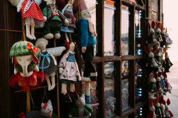 Soft toy of cotton in the store. Handmade doll with colorful woolen clothes in souvenirs shop. Colorful traditional toys selling in the market.