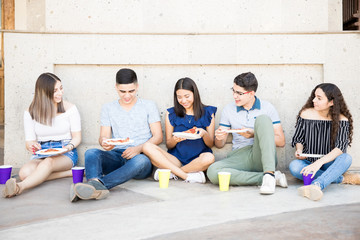 Group of friends having pizza outdoors