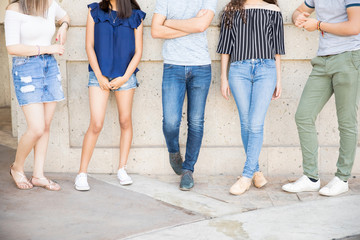 Fototapeta na wymiar Teenagers standing outdoors by a wall